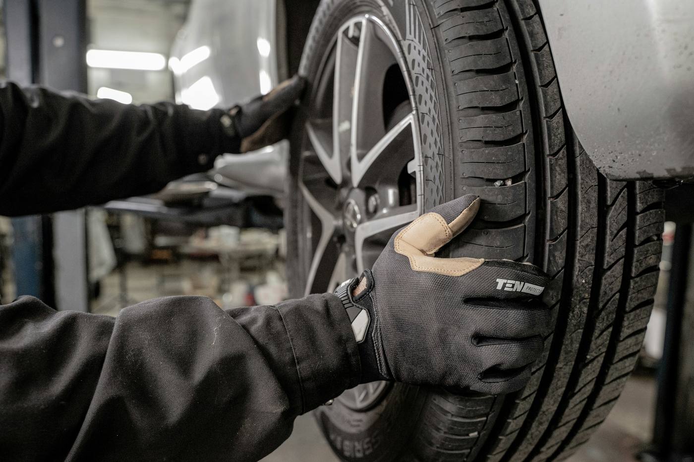 Mechanik w rękawicach przy naprawie przebitej opony, wulkanizacja mobilna Trójmiasto