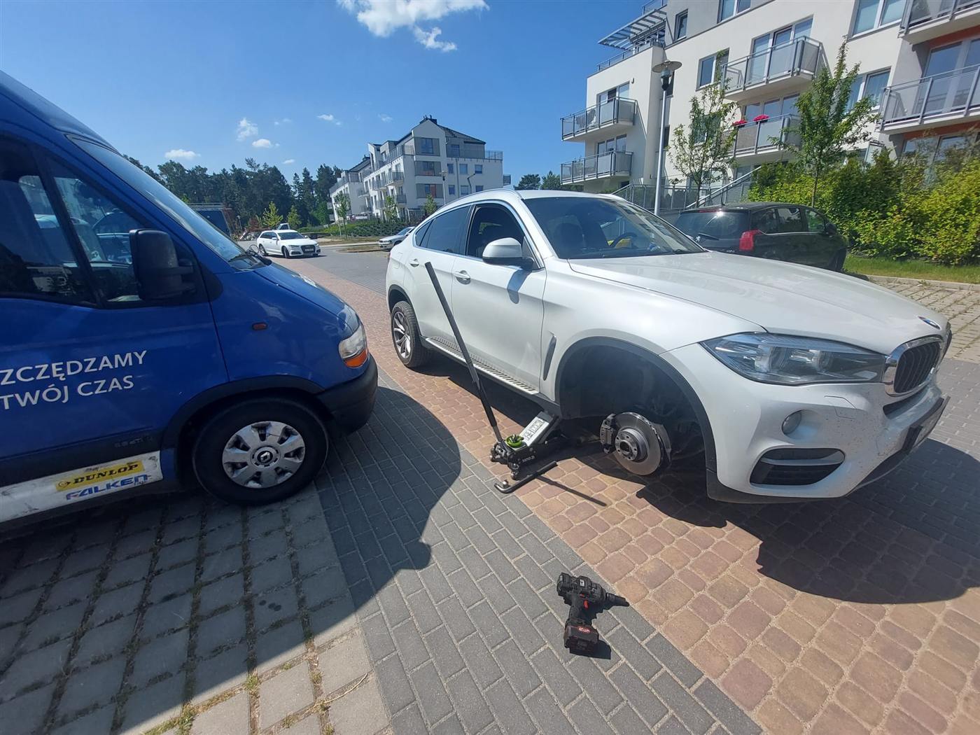Bus Mobile Gum przy wymianie koła BMW na parkingu osiedlowym
